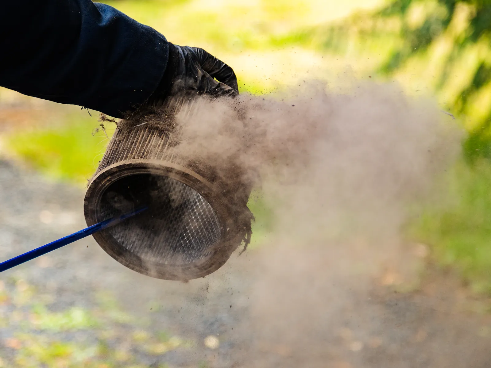 The Vaper 90 blasting dust out of a cartridge filter held in a gloved hand