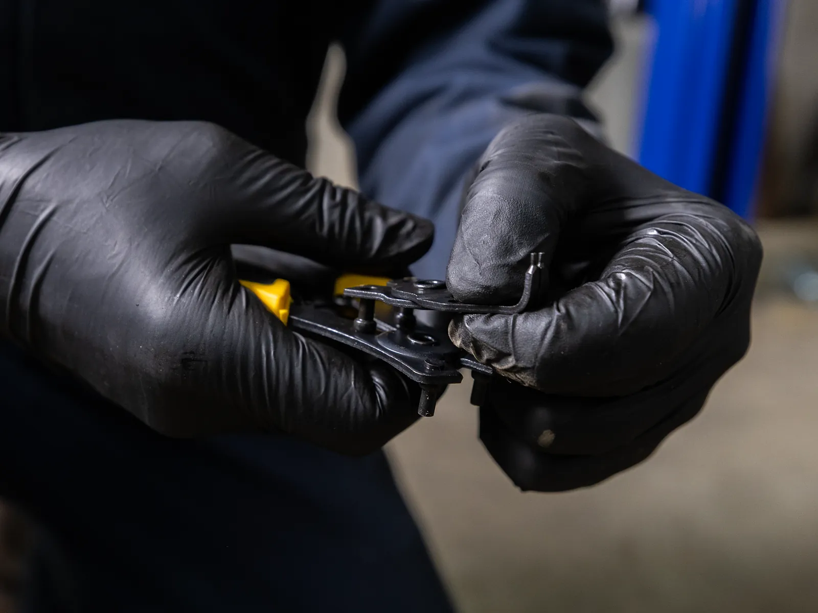 Gloved hands changing a tip on pliers from the 18402 snap ring plier set